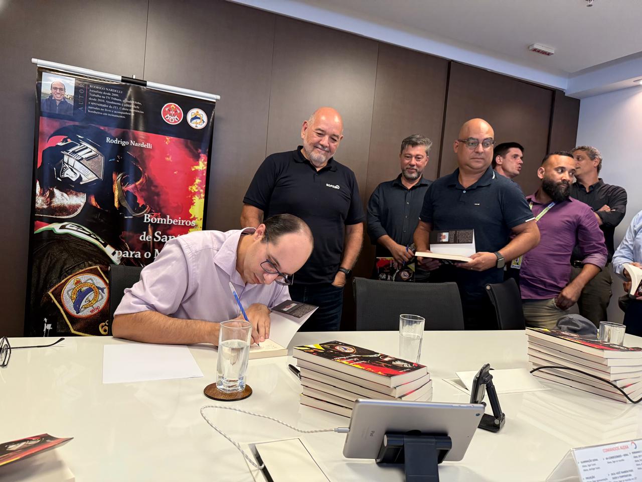 Rodrigo Nardelli autografa livros durante reunião do comitê do SSMA no SOPESP